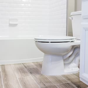 white bathroom toilet with caulking around rim       